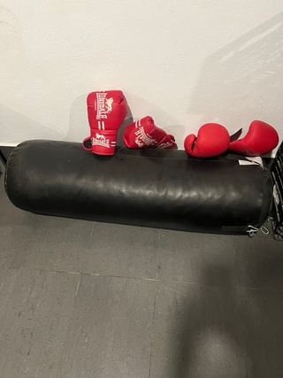 Saco de boxeo negro con guantes y en buen estado