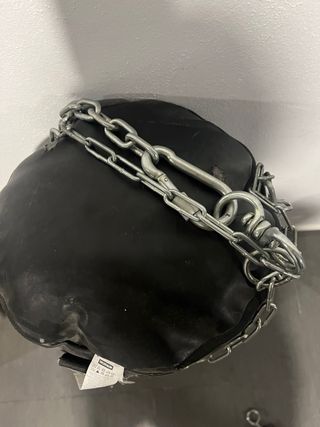 Saco de boxeo negro con guantes y en buen estado