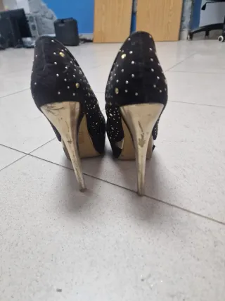 Zapatos de tacón negros con adornos dorados