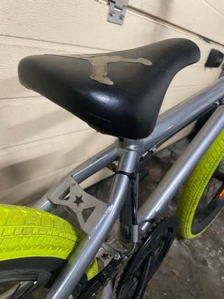 Bicicleta BMX grigia con ruote gialle