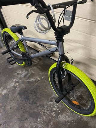 Bicicleta BMX grigia con ruote gialle