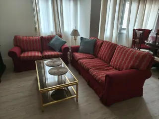 Sofá rojo y dorado con mesa de centro