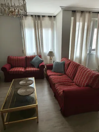 Sofá rojo y dorado con mesa de centro