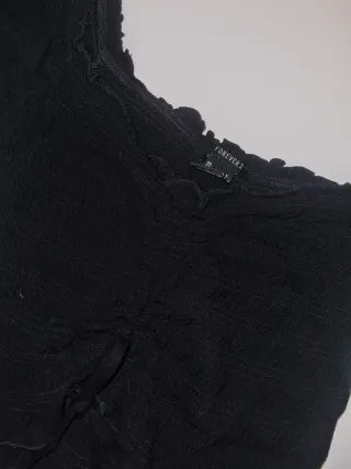 Crop top negro con volantes y cordones