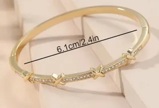 Pulsera dorada con cierre y detalles brillantes.