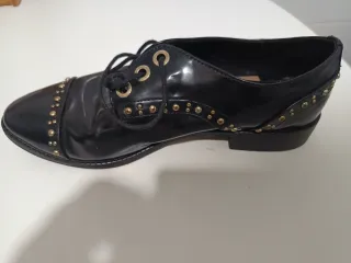 Zapatos negros con tachuelas doradas