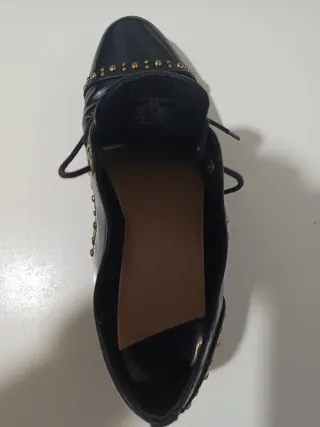 Zapatos negros con tachuelas doradas