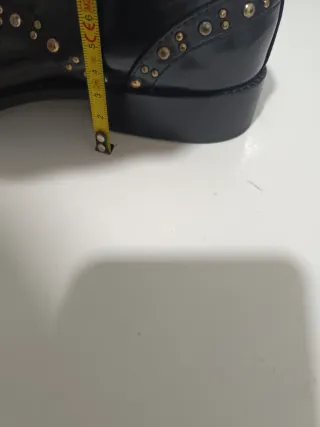 Zapatos negros con tachuelas doradas