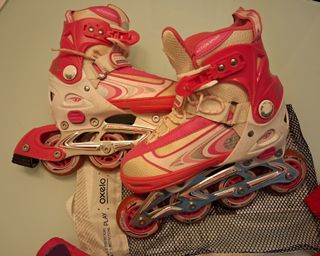 Pattini a rotelle rosa e bianchi con protezioni