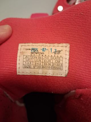 Pattini a rotelle rosa e bianchi con protezioni