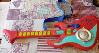 Guitarra de juguete roja con correa azul