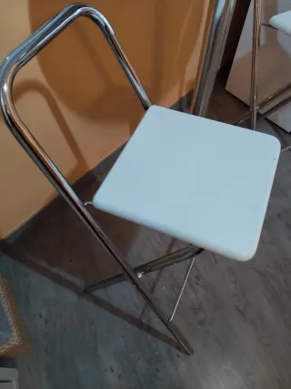 Mesa alta plateada con 2 sillas blancas