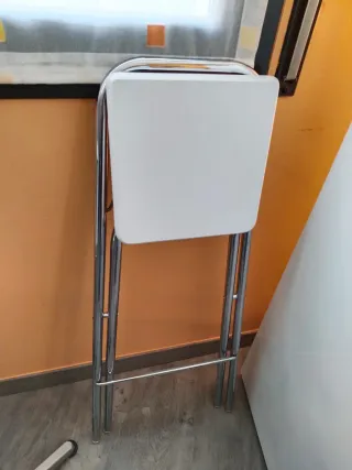 Mesa alta plateada con 2 sillas blancas