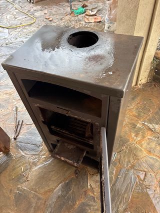 Estufa de leña metálica con puerta de cristal