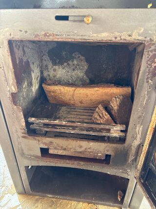 Estufa de leña metálica con puerta de cristal