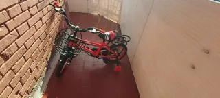 Bicicleta infantil roja con ruedines