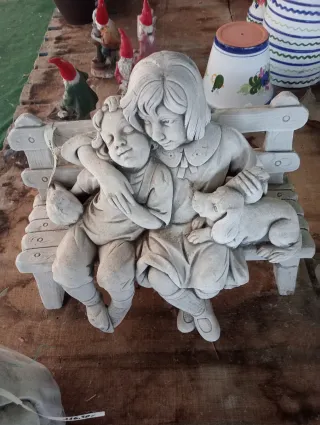 Figura de piedra niños banco jardín
