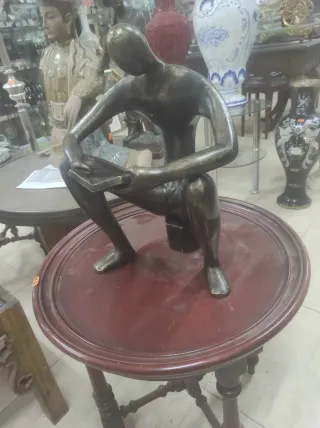 Figura de bronce de hombre leyendo