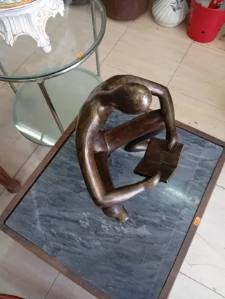 Figura de bronce de hombre leyendo