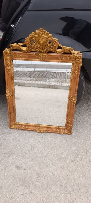 Espejo antiguo dorado con marco tallado..