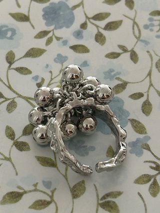 Anillo plateado con diseño de esferas