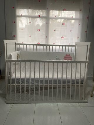 Cuna de bebé blanca con protector