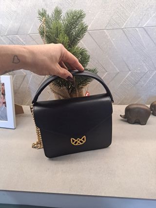 Bolso negro con logo dorado