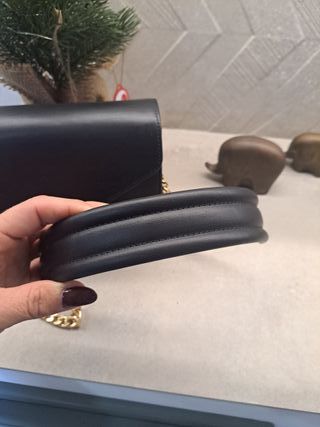 Bolso negro con logo dorado