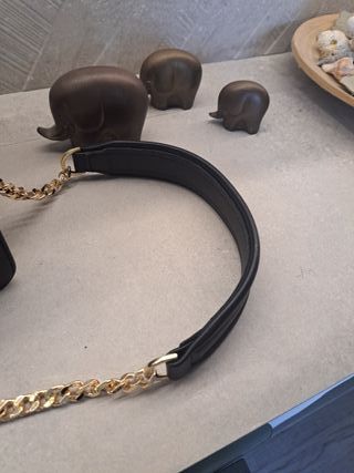 Bolso negro con logo dorado