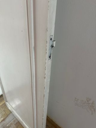 Puerta de madera blanca con manilla dorada