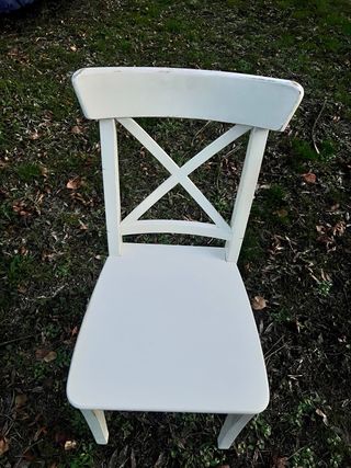 Dos sillas de madera blanca estilo cruz.