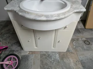 Mueble de baño con lavabo y grifo.