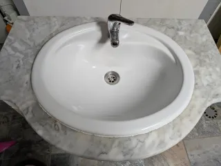 Mueble de baño con lavabo y grifo.