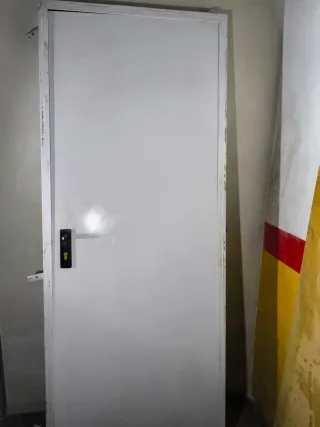 Puerta exterior blanca con cerradura