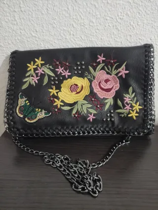 Bolso negro con bordado floral y mariposa