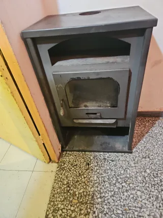 Estufa de leña metálica con puerta de cristal