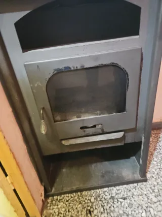 Estufa de leña metálica con puerta de cristal