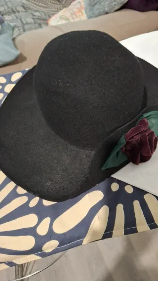 Sombrero negro elegante con flor color vino.