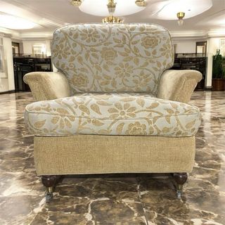 Sillón de tela beige y dorado