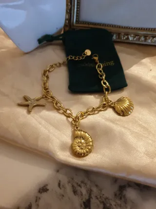 Pulsera dorada con charms marinos