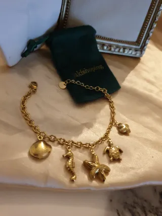 Pulsera dorada con dijes marinos