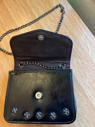 Cartera negra con cadena y cruz