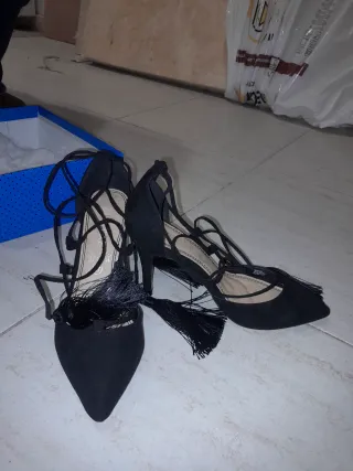 Tacones negros con cordones y flecos
