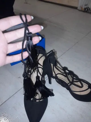 Tacones negros con cordones y flecos