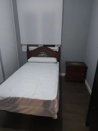 Dormitorio con escritorio y silla de madera con di
