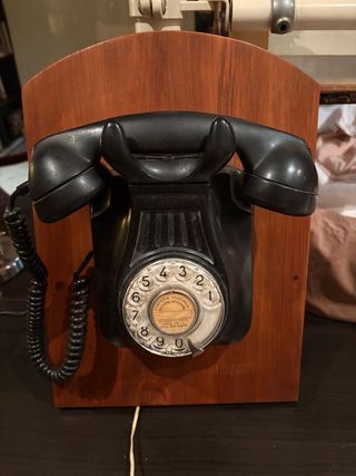 Teléfono antiguo  sobre soporte de madera