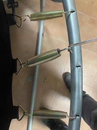 Cama elástica verde con red de seguridad