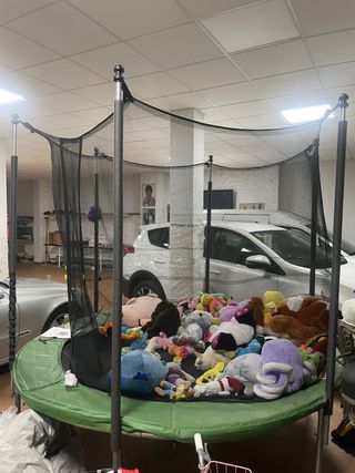 Cama elástica verde con red de seguridad