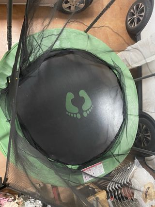 Cama elástica verde con red de seguridad