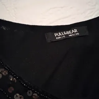 Vestido negro con lentejuelas negras y doradas.